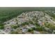 Aerial view of a residential neighborhood with houses, trees, and a lake at 24839 Wild Frontier Dr, Land O Lakes, FL 34639