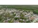 Aerial view of a residential neighborhood with lush trees, pond, and houses at 24839 Wild Frontier Dr, Land O Lakes, FL 34639
