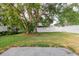 Spacious backyard featuring green grass, mature trees, and a white privacy fence at 24839 Wild Frontier Dr, Land O Lakes, FL 34639
