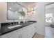 Elegant bathroom featuring a double vanity with dark countertops and bright white cabinets and ample lighting at 2718 N 21St St, Tampa, FL 33605