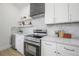 Kitchen boasts stainless steel appliances, custom cabinets, marble countertops, beverage cooler, and gray hood at 2718 N 21St St, Tampa, FL 33605