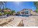 Inviting backyard with pool, waterfall, lounge chairs, and travertine pavers, perfect for outdoor entertaining at 300 10Th Ave, Indian Rocks Beach, FL 33785
