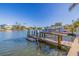 Wooden dock extending into the canal, with boat lift and waterfront views at 300 10Th Ave, Indian Rocks Beach, FL 33785