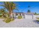 Charming home featuring a white exterior, well-manicured landscaping, and a paved driveway to a one car garage at 300 10Th Ave, Indian Rocks Beach, FL 33785
