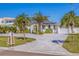 Charming single-story home with a well-manicured lawn, palm trees, and a paved driveway leading to an attached garage at 300 10Th Ave, Indian Rocks Beach, FL 33785