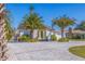 A charming home showcasing a paver driveway, lush landscaping, and a welcoming entrance at 300 10Th Ave, Indian Rocks Beach, FL 33785