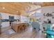 Bright kitchen with an island, open concept to the living area, stainless appliances, and wood-paneled vaulted ceilings at 300 10Th Ave, Indian Rocks Beach, FL 33785