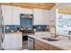 Well-lit kitchen with white cabinets, blue subway tile backsplash, butcher block countertops, and stainless steel appliances at 300 10Th Ave, Indian Rocks Beach, FL 33785