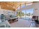 Bright living room featuring wood ceiling, beach decor, water views, and access to the outdoor pool area at 300 10Th Ave, Indian Rocks Beach, FL 33785