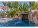 Beautiful pool with rock waterfall feature surrounded by lush tropical landscaping at 300 10Th Ave, Indian Rocks Beach, FL 33785