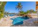 Backyard pool with tropical landscaping, comfortable lounge chairs, and picturesque waterfront views at 300 10Th Ave, Indian Rocks Beach, FL 33785