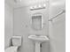 Small bathroom featuring a pedestal sink, toilet, and a simple round mirror with overhead lighting at 314 Barlow Ave # 73, Sarasota, FL 34232