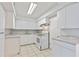 Compact kitchen features white cabinets, marble countertops, and white appliances, including a range and oven at 314 Barlow Ave # 73, Sarasota, FL 34232