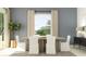 Bright dining area with a wood table, white chairs, and neutral curtains at 31670 Cannon Rush Dr, San Antonio, FL 33576