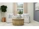 Bright living room featuring white armchairs, a round coffee table, and ample natural light at 31670 Cannon Rush Dr, San Antonio, FL 33576