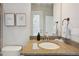 Bathroom vanity with granite countertop, framed botanical prints, and doorway view at 3227 Watermark Dr, Wesley Chapel, FL 33544