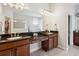 Spacious bathroom featuring dual sinks, dark wood cabinets, a large mirror, and tiled floors at 3227 Watermark Dr, Wesley Chapel, FL 33544