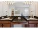 Spacious bathroom featuring dual sinks, dark wood cabinets, a large mirror, and tiled floors at 3227 Watermark Dr, Wesley Chapel, FL 33544