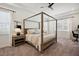 Bedroom featuring a four-poster bed, neutral tones, and two bright windows at 3227 Watermark Dr, Wesley Chapel, FL 33544
