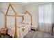 Well-lit bedroom with a unique canopy bed frame, neutral decor, and window with curtains at 3227 Watermark Dr, Wesley Chapel, FL 33544