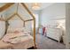 Cozy bedroom featuring a unique canopy bed frame, neutral decor, and lots of natural light at 3227 Watermark Dr, Wesley Chapel, FL 33544