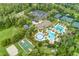 Aerial view of community featuring pools, clubhouse, tennis courts, a sports court and green spaces at 3227 Watermark Dr, Wesley Chapel, FL 33544