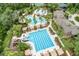 Aerial view of the community pool area with multiple pools, a water slide, cabanas, and lush landscaping at 3227 Watermark Dr, Wesley Chapel, FL 33544