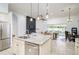 Open concept kitchen with stainless steel appliances, granite island, seamlessly connects to living and dining areas at 3227 Watermark Dr, Wesley Chapel, FL 33544
