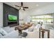 Bright living room with a modern fireplace, large TV, comfortable seating, and sliding glass doors to the backyard at 3227 Watermark Dr, Wesley Chapel, FL 33544