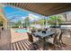 Covered patio area with outdoor kitchen, grill, and dining set at 3227 Watermark Dr, Wesley Chapel, FL 33544