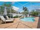 Screened pool area with patio chairs, lush plantings, and shade umbrella at 3227 Watermark Dr, Wesley Chapel, FL 33544