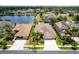An aerial view of the home with a lush lawn, mature landscaping, and a tranquil lake in the neighborhood at 3300 Stonegate Falls Dr, Land O Lakes, FL 34638