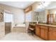 Luxurious bathroom featuring a soaking tub, a walk-in shower, and dual vanities with granite countertops at 3300 Stonegate Falls Dr, Land O Lakes, FL 34638
