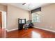 Office bedroom with hardwood floors, a large window with blinds, and a black wooden desk at 3300 Stonegate Falls Dr, Land O Lakes, FL 34638