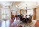 Elegant dining room boasts coffered ceilings, a grand chandelier, and a beautiful wood table set for a sophisticated dining experience at 3300 Stonegate Falls Dr, Land O Lakes, FL 34638
