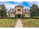 Stately home featuring manicured landscaping, brick facade, and multi-pane windows at 3300 Stonegate Falls Dr, Land O Lakes, FL 34638