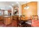 Bright kitchen nook features a built-in bench with decorative pillows and a round table under a unique chandelier at 3300 Stonegate Falls Dr, Land O Lakes, FL 34638
