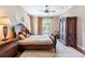 Elegant bedroom with ornate wooden furniture, a ceiling fan, and plenty of natural light at 3300 Stonegate Falls Dr, Land O Lakes, FL 34638