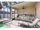 Covered outdoor kitchen and patio area with a stainless steel grill and lounge chairs at 3300 Stonegate Falls Dr, Land O Lakes, FL 34638