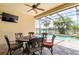 Outdoor patio with a dining set, ceiling fan, and views of the screened-in pool at 3300 Stonegate Falls Dr, Land O Lakes, FL 34638