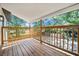 This covered wood balcony is large, with a wood railing that overlooks the backyard at 3316 W Napoleon Ave, Tampa, FL 33611