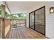 This covered wood balcony has wood railing and black framed sliding glass door that leads into the house at 3316 W Napoleon Ave, Tampa, FL 33611