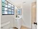 Well-lit bathroom featuring a modern vanity with a black faucet, a decorative mirror, and a large window at 3316 W Napoleon Ave, Tampa, FL 33611