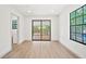 A light-filled bedroom boasts a new floor, a window, and sliding doors to a balcony at 3316 W Napoleon Ave, Tampa, FL 33611