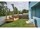 Backyard featuring a wooden deck, fenced yard, and a well-maintained lawn, and a bright blue exterior at 3402 W Clifton St, Tampa, FL 33614