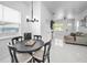 Bright dining area features modern chandelier and table with seating; open concept living space visible at 3402 W Clifton St, Tampa, FL 33614