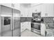 Well-lit kitchen features stainless steel appliances and contemporary backsplash and white cabinetry at 3402 W Clifton St, Tampa, FL 33614