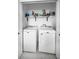 Efficient laundry room with full-size washer and dryer and storage space on the shelf above at 3402 W Clifton St, Tampa, FL 33614