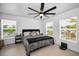 Bright bedroom with two windows, a ceiling fan, and a comfortable queen-sized bed with hardwood floors at 3402 W Clifton St, Tampa, FL 33614
