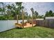 Outdoor wooden deck space with seating, a fire pit, and green grass for outdoor gatherings at 3402 W Clifton St, Tampa, FL 33614